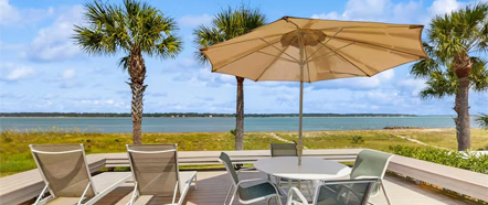 Beach Properties a table chairs and umbrella on a deck