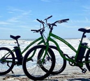 avocado bikes hhi A couple of bikes parked on a beach by the water