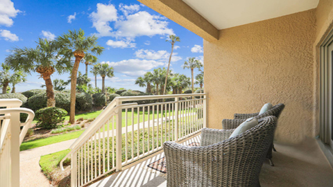 459 Captain's Walk. wicker chairs on a first floor balcony looking out at palm trees